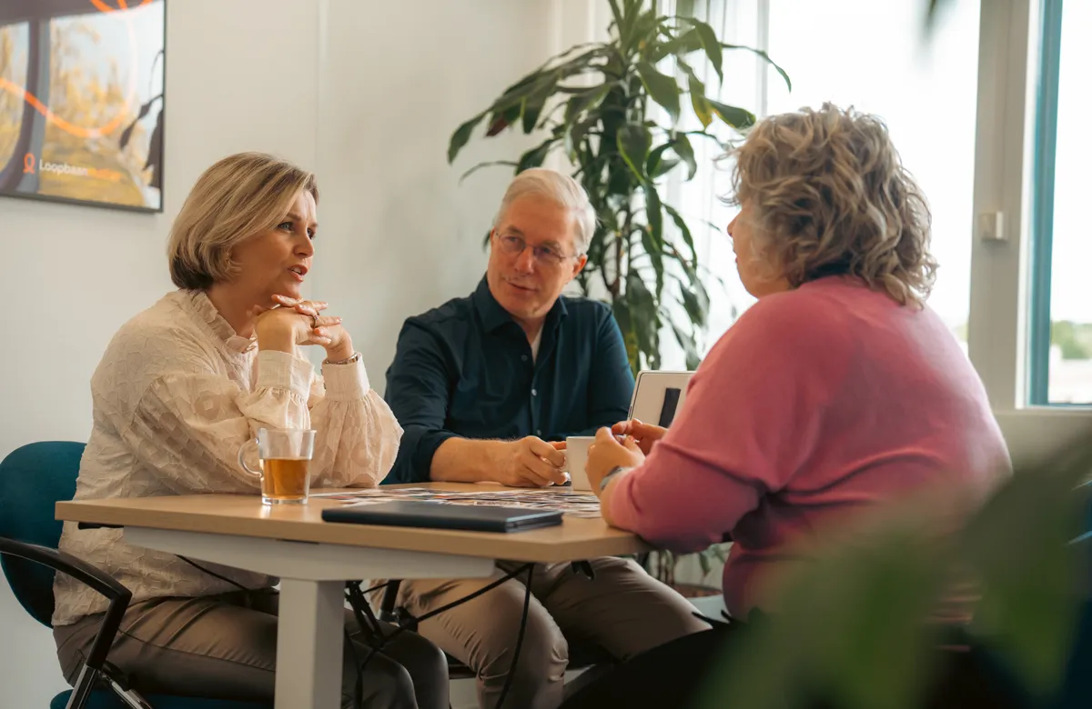 Teamsessie met drie mensen aan tafel